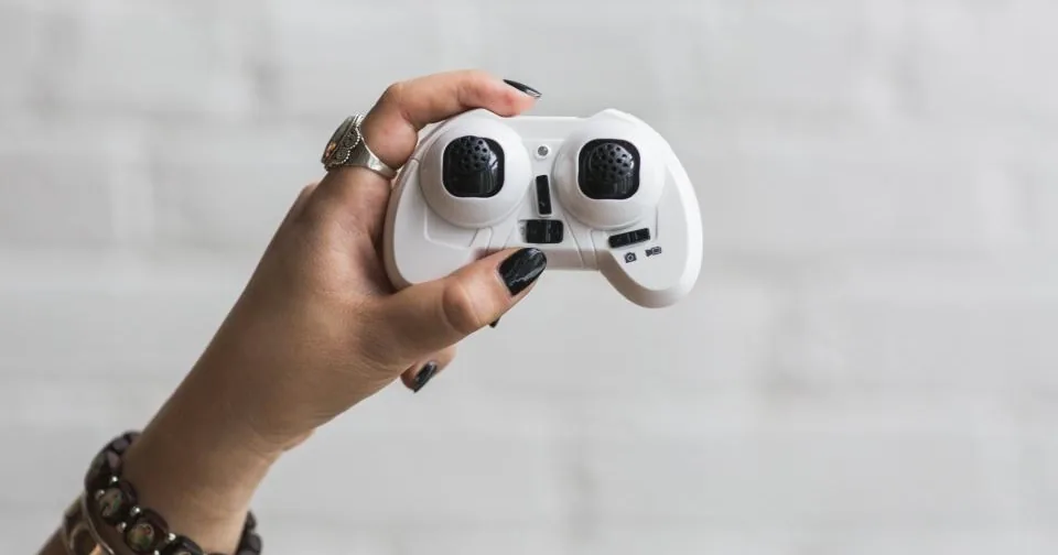 Una mano che tiene un piccolo controller bianco